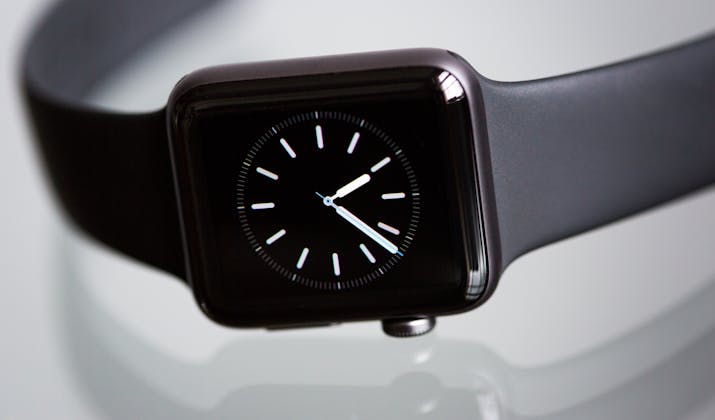 How to Set Up Your Apple Watch Without an iPhone 3 Close-up of black Apple Watch face with analog clock on sport band.