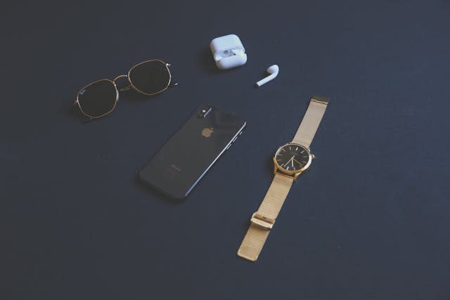 How To Check Apple Product Coverage 3 Flat lay of iPhone, AirPods, and Apple Watch accessories on desk