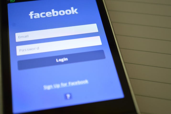 What Do The Green Dots Mean On Facebook ? 3 Smartphone displaying the Facebook login page with email and password fields beside a lined notebook