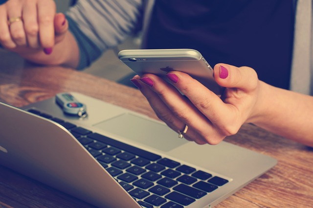 Unlock the Power of iPhone USB Tethering 1 Person using iPhone while working on MacBook with USB drive on desk