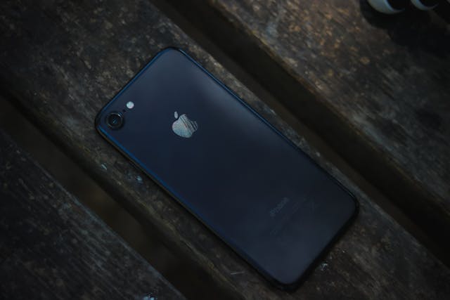 How To Check Apple Product Coverage 4 Used black iPhone on wooden bench second-hand Apple smartphone close-up