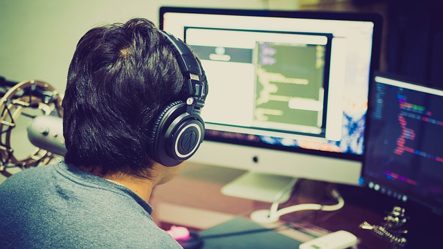 What Comes In The Box While Purchasing iMac 5 Developer coding on iMac with headphones
