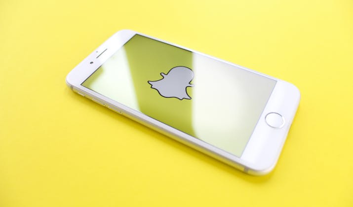 What Happens If You Block Someone On Snapchat? 1 iPhone displaying Snapchat logo on yellow background