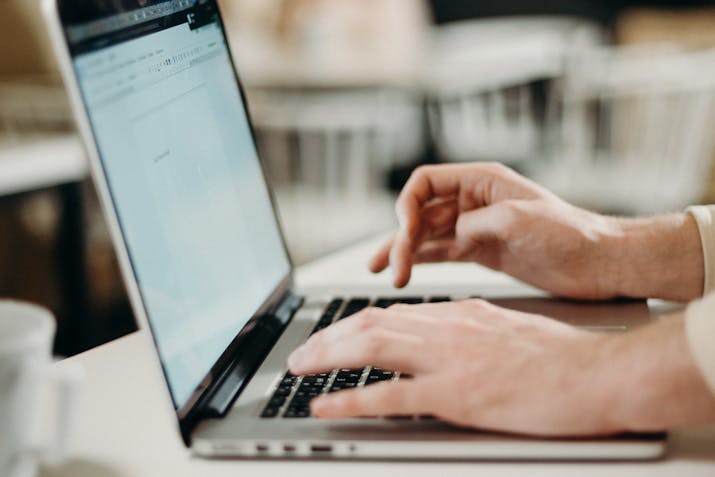 How to Access and Manage Your Spectrum Email 1 Close-up of hands typing on a laptop keyboard while working online.