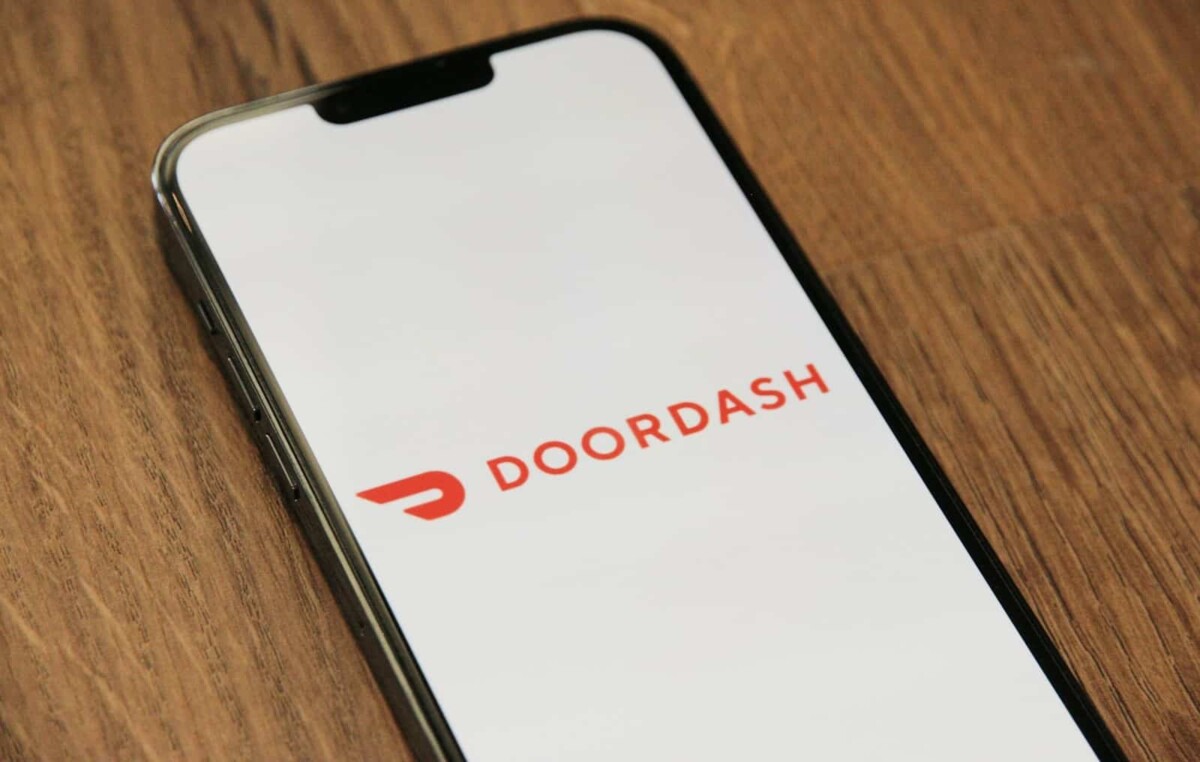 DoorDash food delivery app logo on smartphone screen on wooden table