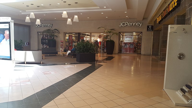 Inside mall view of JCPenney storefront with seating area.
