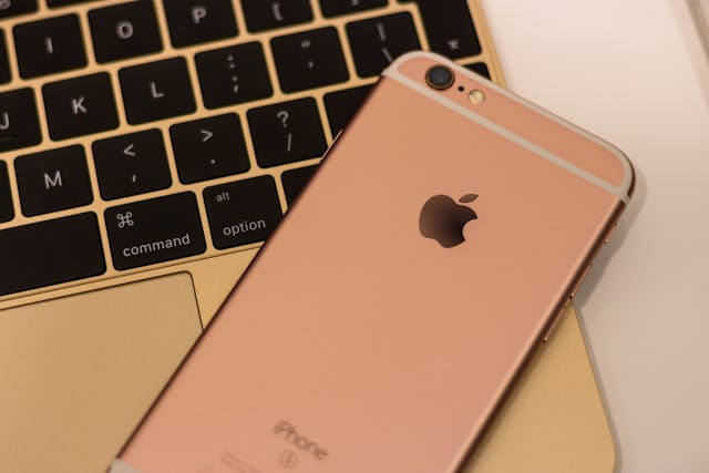 Rose gold iPhone on MacBook keyboard