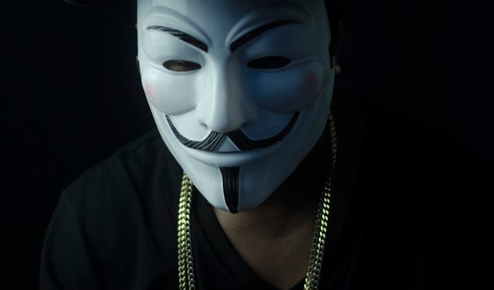 How Do Roblox Accounts Get Hacked? 1 Anonymous hacker in Guy Fawkes mask symbolizing Roblox account compromise.