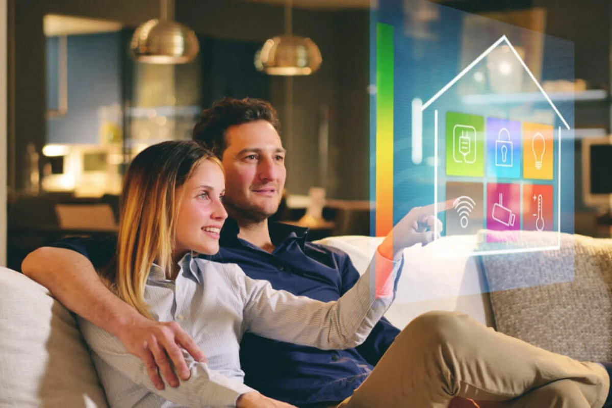 A couple sitting on the couch seemingly touching a hologram.